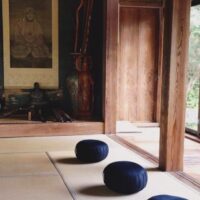縁側に面した和室に座布団が並べられ、奥には掛け軸や仏像が飾られた、静かで落ち着いた坐禅空間。