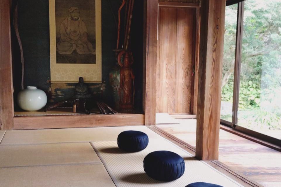 縁側に面した和室に座布団が並べられ、奥には掛け軸や仏像が飾られた、静かで落ち着いた坐禅空間。
